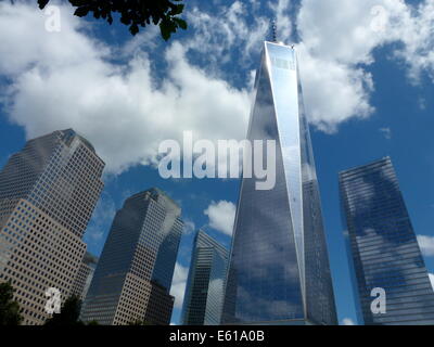 Miroir nuages sur la façade de One World Trade Center (WTC 1) bureau highrise, précédemment connu sous le nom de la tour de la liberté, situé à côté du World Financial Center (WFC) (L) à New York City, USA, 20 juin 2014. Le WTC 1 gratte-ciel a été construit sur le site également connu sous le nom de Ground Zero, qui a vu la destruction du World Trade Center à l'attaque terroriste du 11 septembre 2001. Le bâtiment qui est en construction depuis 2006 est la plus haute construite dans le United States, mesure 541,3 mètres. Photo : Alexandra Schuler/DPA - PAS DE FILS DE SERVICE - Banque D'Images