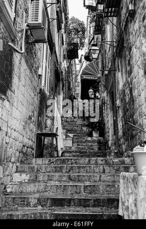 Image en noir et blanc d'une rue étroite à épaulement raide retour à Dubrovnik, Croatie Banque D'Images