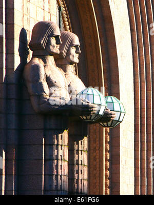 Gardien de pierre sculptée dans le granit finlandais statues holding light globe terrestre à la recherche du côté de la gare d'Helsinki Banque D'Images