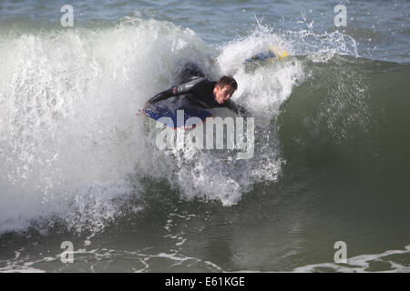 Newquay, Cornwall, UK. 10e Août, 2014. Météo : Les restes de l'ouragan Bertha a frappé la côte de Cornouailles provoquant une mer difficile et de hautes vagues. Les jeunes et les vieux profiter de la haute mer. Credit : Nicholas Burningham/Alamy Live News Banque D'Images