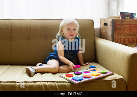 Girl (2-3) sitting on sofa Banque D'Images