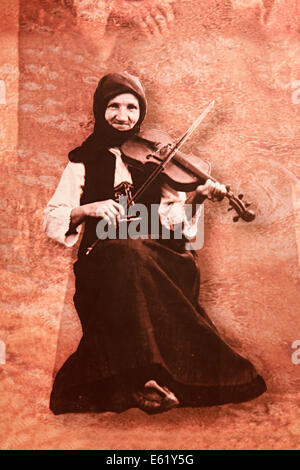 Les images du Musée National de Gucha serbe Serbie 08,2014, vieille femme dans le costume national serbe est assis et joue du violon Banque D'Images