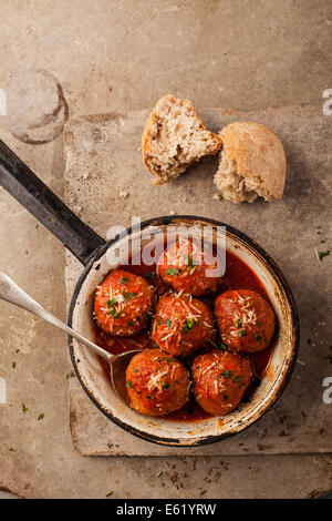 Des boulettes de viande cuites dans la sauce tomate dans le moule, sur fond gris Banque D'Images