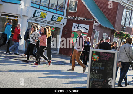 Les gens, les magasins, restaurants et pubs à pied du côté de la rue Laugavegur, dans le centre de Reykjavik sur une journée ensoleillée en Islande Banque D'Images