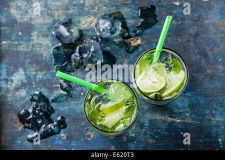 Verre de cocktail mojito glacé à la menthe sur fond bleu Banque D'Images