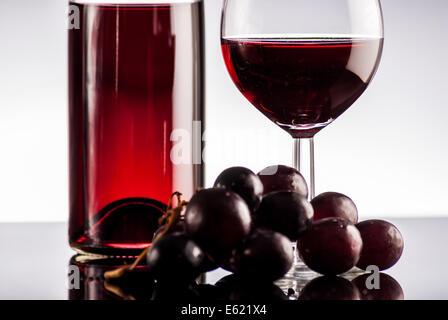 Vin rouge en bouteille sur fond noir refléter Banque D'Images