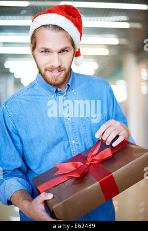 Portrait d'un jeune homme déballage de cadeau de Noël Banque D'Images