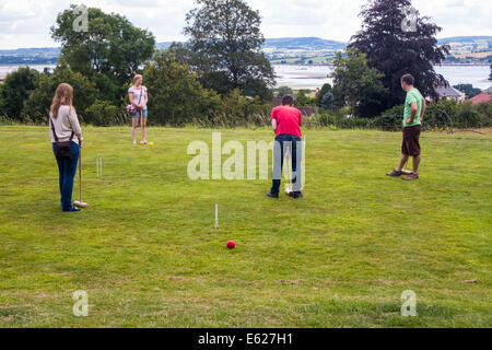Août 2014. Un groupe d'élèves et amis de jouer au croquet sur la pelouse en face d'une maison de campagne La Ronde en Exmouth, Devon. Banque D'Images