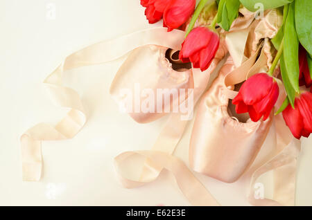 Chaussures de ballet et de tulipes rouges sur fond blanc Banque D'Images