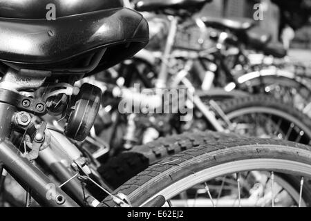 Image en noir et blanc de bicyclettes garées dans une rangée. Banque D'Images