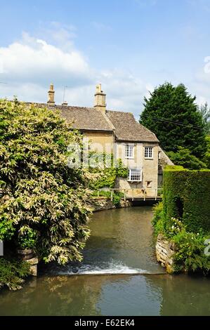 Vue sur le barrage sur la rivière Windrush avec riverside cottages à l'arrière, Burford, Oxfordshire, Angleterre, Royaume-Uni, Europe de l'Ouest. Banque D'Images