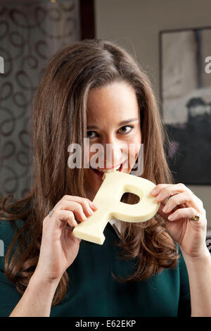 Pippa Middleton pose avec du chocolat tout en étant assis et tenant une grande lettre « P » en chocolat blanc. Banque D'Images