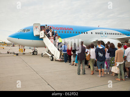 Les passagers de monter dans un avion de Thomson à l'aéroport de Gatwick, Londres. Banque D'Images