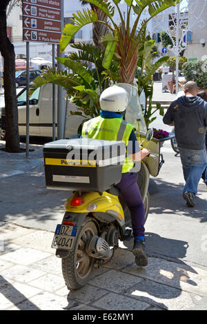 Facteur italien sur moto avec grande boîte à l'arrière des livraisons dans le centre-ville de Polignano a Mare Banque D'Images