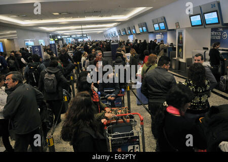 Buenos Aires, Argentine. 12e Août, 2014. Les gens restent bloqués dans un aéroport pendant une grève promue par l'Association des pilotes de ligne (APLA, pour son sigle en espagnol) et l'Union européenne de la conduite d'Air aviateurs (UALA, pour son sigle en espagnol), à Buenos Aires, Argentine, le 12 août, 2014. Une grève mis en durée indéterminée par des pilotes d'air les entreprises qui a été qualifié par les compagnies aériennes de l'Argentine comme une mesure 'inopportune, disproportionnée et déraisonnable", a causé des retards et l'annulation des vols locaux et internationaux en Argentine le mardi. Credit : Enrique Cabrera/TELAM/Xinhua/Alamy Live News Banque D'Images