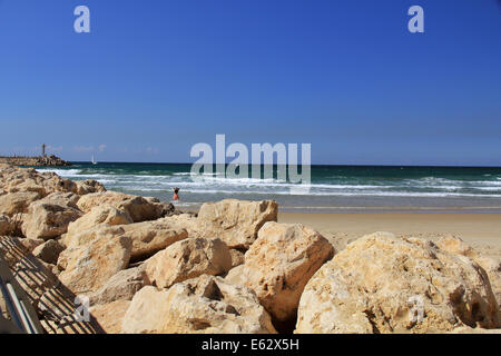 Rock sea wall avec petit phare sur la mer Méditerranée à Herzliya Israël près de Jaffa et Tel Aviv. Banque D'Images