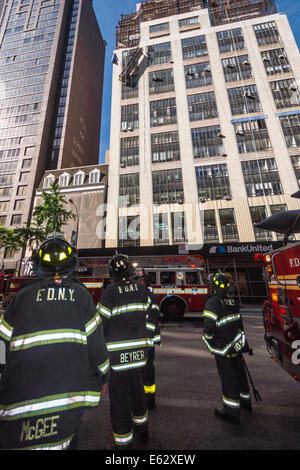 Manhattan, New York. Membres du service d'incendie observer un accident de travail sur un bâtiment.Ladders et de moteurs prêts à intervenir Banque D'Images