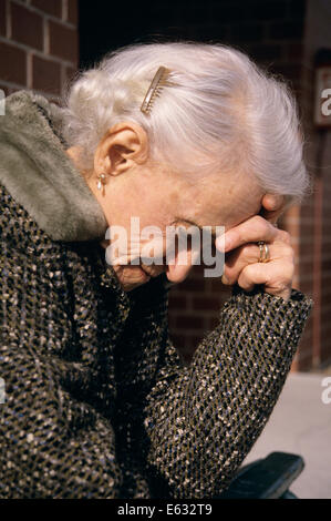 Des années 80, femme plus âgée, HOLDING HEAD IN HAND Banque D'Images