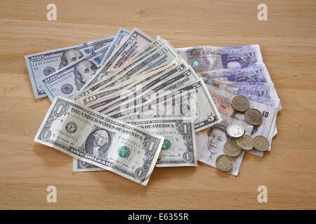 Une pile d'argent américain et britannique sur une table. Banque D'Images