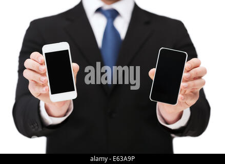 Businessman showing smartphones avec écrans vierges Banque D'Images