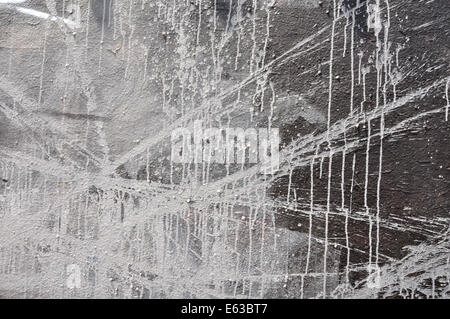 Peinture blanche tachée sur mur noir. Résumé fond. Banque D'Images