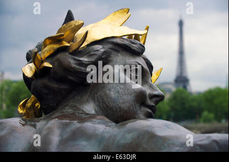 Paris France Pont Pont Alexandre III détail statue de nymphe avec couronne d'or et de la Tour Eiffel Banque D'Images