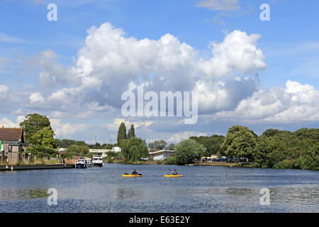 Walton-on-Thames, Surrey, Angleterre, Royaume-Uni. 13 août 2014. Météo : Encore une journée ensoleillée et douches cumulus moelleux voit dériver dans le ciel au-dessus de la Tamise à Walton, comme deux canoéiste pagaie en. Credit : Julia Gavin/Alamy Live News Banque D'Images