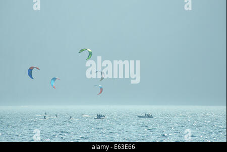 Kite surfeurs retour éclairé par le soleil du soir jouer avant que les montagnes sur le lac de Garde, Italie Banque D'Images