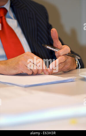 Les mains des hommes avec un stylo sur la table dans un bureau au cours d'une réunion Banque D'Images