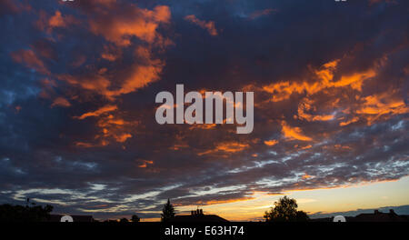 Wimbledon, au sud ouest de Londres au Royaume-Uni. 13 août 2014. Météo : vue panoramique au-dessus des toits de Wimbledon avec coucher du soleil orange glow après une journée de soleil, douches et des vents en rafales. Credit : Malcolm Park editorial/Alamy Live News. Banque D'Images