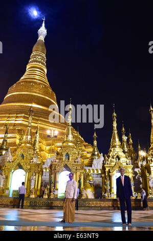 Le secrétaire d'Etat John Kerry, pose pour les photographes comme une quasi-pleine lune se lève au-dessus de la Shwedagon Pagoda bouddhiste au cours de sa visite à Rangoon, en Birmanie, au mois d'août. 10, 2014. Banque D'Images