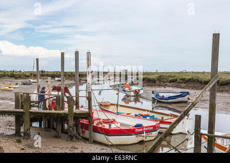 Les bateaux sur des jetées en bois échouent à marée basse à Morston, Norfolk, en préparation pour des excursions en bateau pour voir les phoques à Blakeney point Banque D'Images