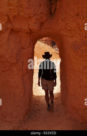 Randonneur et tunnel sur la Queen's Garden Trail à travers les cheminées de fée, Bryce Canyon National Park, Utah, USA Banque D'Images