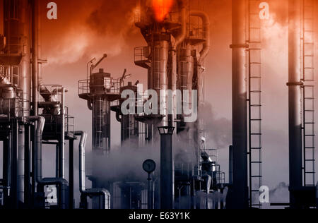 Raffinerie de pétrole et de gaz avec l'heure du coucher du soleil à flammes géant Banque D'Images