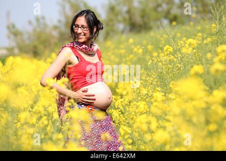 Saint Peter Ording (Allemagne). 20 mai, 2014. ILLUSTRATION - une femme dans le neuvième mois de grossesse se trouve dans un champ de fleurs à Saint Peter Ording, Allemagne, 20 mai 2014. Photo : Marques Bodo - MODÈLE LIBÉRÉ/dpa/Alamy Live News Banque D'Images