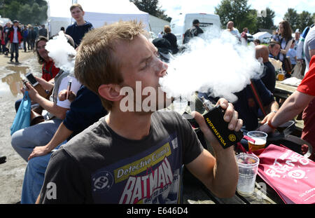 L'homme exhale les vapeurs de Volkswagen e cigarette à Vapefest 2014 Banque D'Images