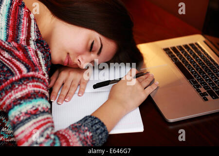 Tired woman dormir sur la table à la maison Banque D'Images