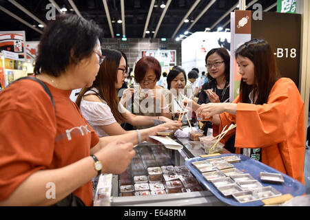 Hong Kong, Chine. 14e Août, 2014. Essayez d'alimentation japonaise lors de la 25e Food Expo à Hong Kong, Chine du Sud, 14 août 2014. L'Expo a débuté le jeudi et les visiteurs sera introduit pour une large gamme de produits alimentaires par la qualité des fournisseurs de partout dans le monde. Credit : Lui Siu Wai/Xinhua/Alamy Live News Banque D'Images