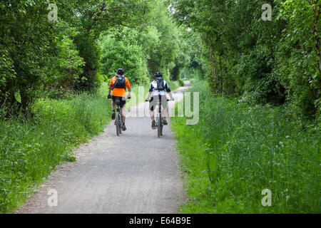 Deux cyclistes sur la piste de Tissington ancienne ligne de chemin de fer Derbyshire Peak District National Park England UK Banque D'Images