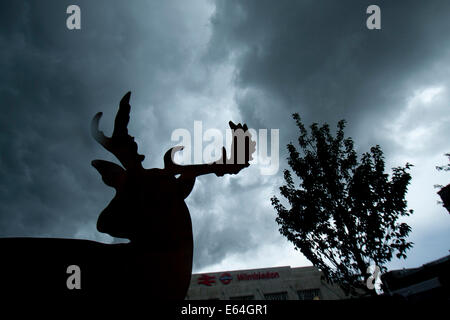 Wimbledon London,UK. 14 août 2014. Météo : un cerf sculpture silhouette sombre sous des nuages d'orage menaçant dans le centre-ville de Wimbledon avant la pluie Crédit : amer ghazzal/Alamy Live News Banque D'Images