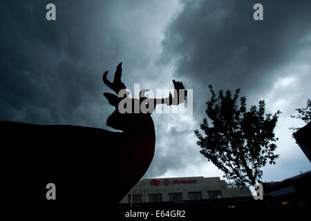 Wimbledon London,UK. 14 août 2014. Météo : un cerf sculpture silhouette sombre sous des nuages d'orage menaçant dans le centre-ville de Wimbledon avant la pluie Crédit : amer ghazzal/Alamy Live News Banque D'Images