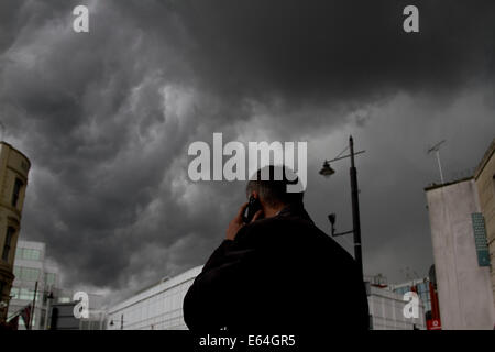 Wimbledon London,UK. 14 août 2014. Météo : Les piétons marchent sous des nuages menaçants sombre dans le centre-ville de Wimbledon avant la pluie Crédit : amer ghazzal/Alamy Live News Banque D'Images