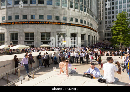 Les employés de bureau se détendre après le travail sur un soir d'été - Canary Wharf - Londres Banque D'Images