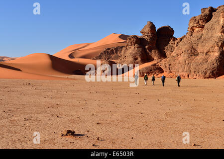 Les gens de la randonnée entre les rochers et les dunes de Tin Merzouga, Tadrart région, le Tassili n'Ajjer National Park Banque D'Images