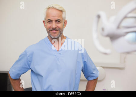 Dentist smiling at camera in blue scrubs Banque D'Images