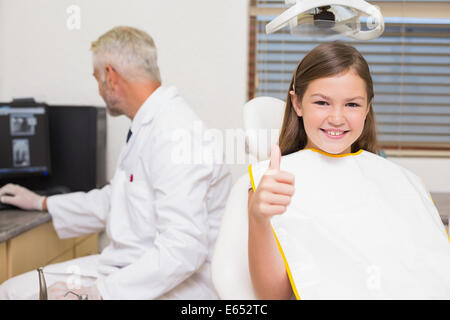 Smiling little girl showing Thumbs up en dentistes président Banque D'Images