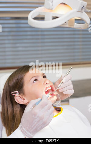 Dentiste à l'aide de l'enrouleur sur la bouche petite fille Banque D'Images