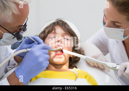 Assistant dentiste pédiatrique et de l'examen d'un petit garçons dents Banque D'Images