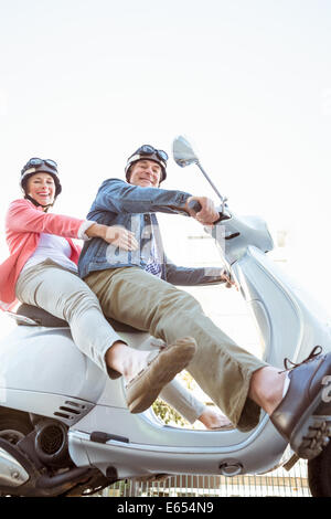 Happy senior couple riding a scooter Banque D'Images