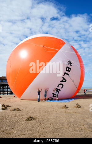 Blackpool détient maintenant le record Guiness pour le plus grand ballon de plage dans l'histoire. La station balnéaire avait sa réalisation validée par Guiness Records comme il a gonflé le ballon d'un diamètre de 18 mètres sur la plage adjacente à Central Pier à Blackpool. Le ballon de plage est de trois fois la taille d'une maison typique et est la même hauteur que la Maison Blanche à Washington DC, USA. Vendredi 15 Août 2014 Banque D'Images